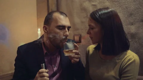 A man in a bar drinks whiskey and smokes a cigarette Stock Footage 95938465