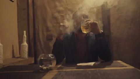 A man in a bar drinks whiskey and smokes a cigarette 스톡 동영상 95953111