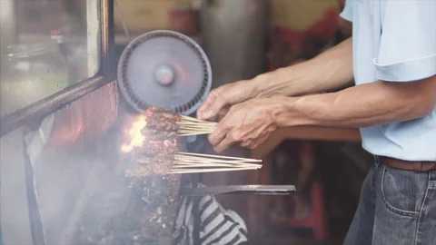 Man barbecuing satay over huge fire popular food in Malaysia, Indonesia and Stock Footage 86222877