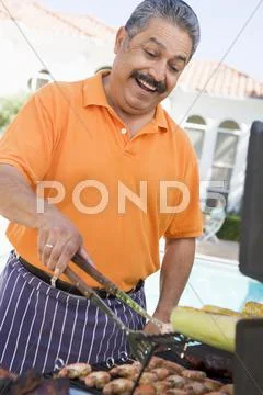 Man barbequing in a garden Stock-Fotos