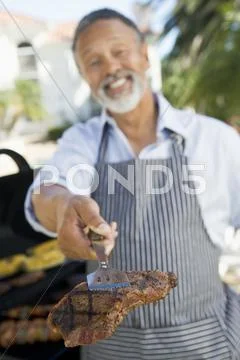 Man barbequing in a garden Stock-Fotos