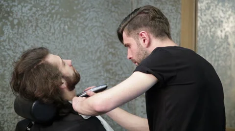 Man barber shaving client's beard Stock Footage 62978112