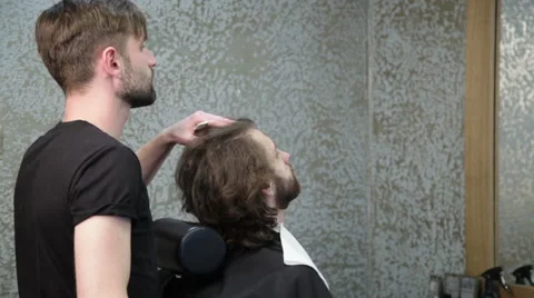 Man barber shaving client's beard Stock Footage 62978595