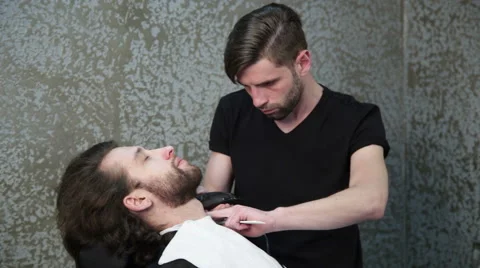 Man barber shaving client's beard Stock Footage 62980238