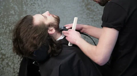 Man barber shaving client's beard Stock Footage 62980849