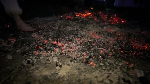 Man with bare heels stepping on hot coals Stock Footage 64840927