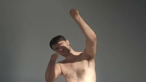 Man with bare torso and amputated hands hides from sunlight 库存影片 194604425