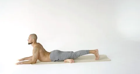 A man with a bare torso and gray pants doing yoga on a white background. Sports Vídeo Stock 117509551