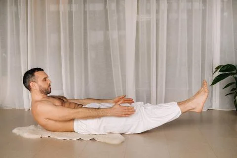 A man with a bare torso does yoga in a fitness room. the concept of a healthy Stock Photos