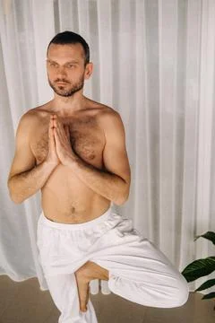 A man with a bare torso does yoga in a fitness room. the concept of a healthy Stock Photos