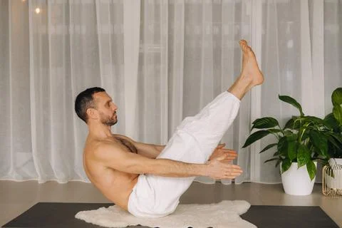 A man with a bare torso does yoga in a fitness room. the concept of a healthy Foto stock