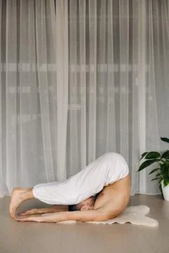 A man with a bare torso does yoga in a fitness room. the concept of a healthy Stock Photos