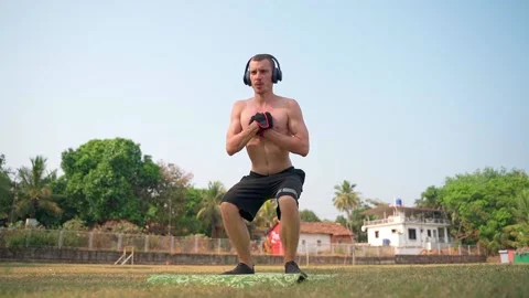 A man with a bare torso is squatting. Slow motion video. Video stock 231337191