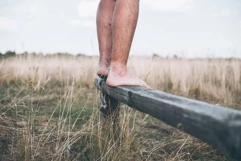 Man barefoot on the log in daylight Stock Photos