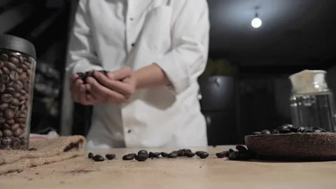 Man barista bar keeper throwing coffee beans to camera Video stock 143256496