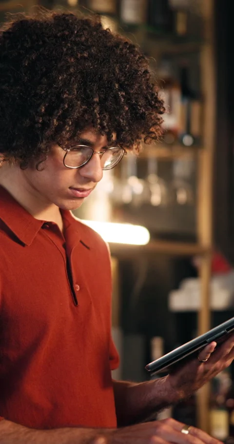 Man, bartender and reading with tablet at bar for inventory, drink menu and Stock Footage 329364868