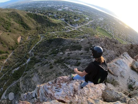 Man base jumps from rock ledge Stock Footage 115727615