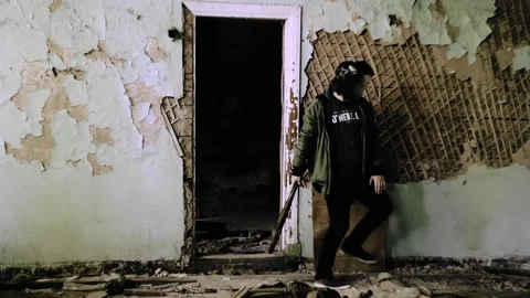 A man with a baseball bat and a protective mask is sneaking around Stock Footage 230192888