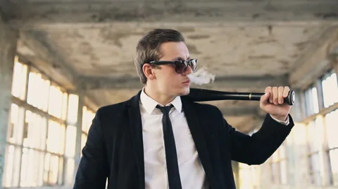 Man with a baseball bat smokes electronic cigarette Stock Footage 67376901