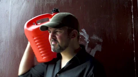 Man in a baseball cap holding a red canister 4K Stock-Footage 196727502