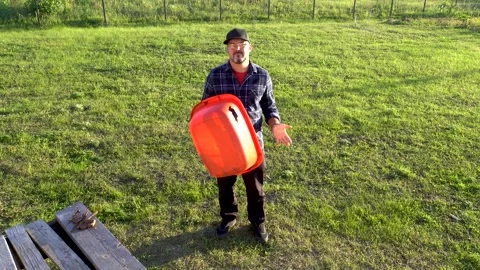 A man in a baseball cap holds a trough in his hands 4K Stock Footage 320866345
