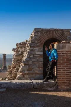 Man in baseball cap NYC is sitting under the arc of The Gate of Augustus in Stock Photos