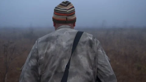 A man with a basket is walking across the field among the fog Stock Footage 124209013
