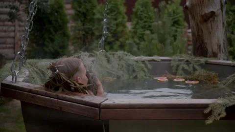 Man in bath with herbal tinctures enjoys the smell of bouquet of dried wormwood Stock Footage 221977757