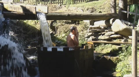 Man bathing in barrel of cold water outdoors Stock Footage 34435056