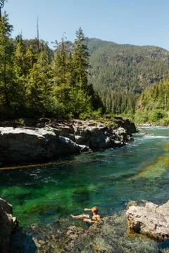 Man bathing in green river in the forest Stock Photos