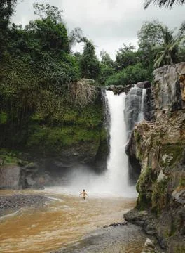 A man is bathing in a waterfall Stock Photos