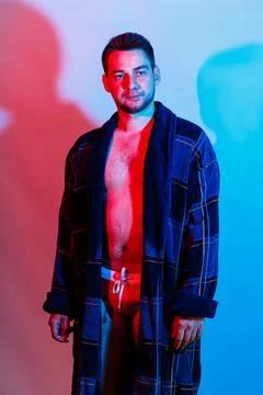 A man in a bathrobe and underwear. Studio lighting red and blue on a male bod Stockfoto's