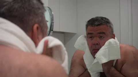 Man in a bathrobe facing back is drying face, hair with a towel. Stock Footage 239764059