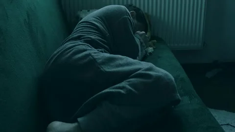 A man in a bathrobe lies or sleeps on the sofa, covering his face with his hands Stock Footage 275505359