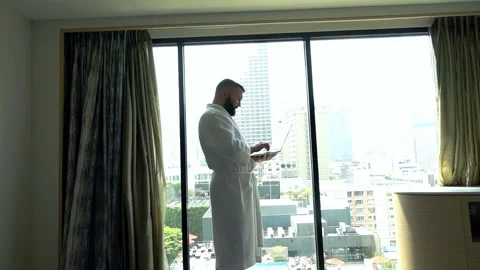 Man in bathrobe using notebook and receives very good news, slow motion shot Stock Footage 88159067