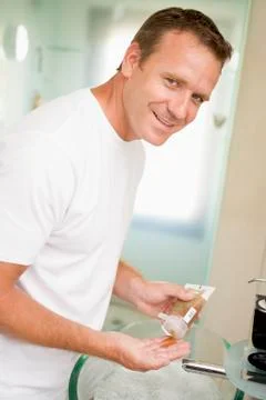 Man in bathroom with hair gel smiling Stock Photos