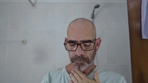 Man in bathroom shaving his beard Stock Footage 288091238