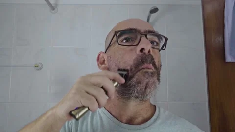 Man in bathroom shaving his beard Stock Footage 288091559