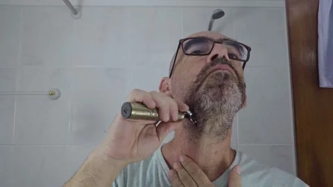 Man in bathroom shaving his beard Stock Footage 288091560