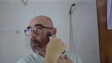 Man in bathroom shaving his beard Stock Footage 288091582