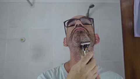 Man in bathroom shaving his beard Stock Footage 288091909