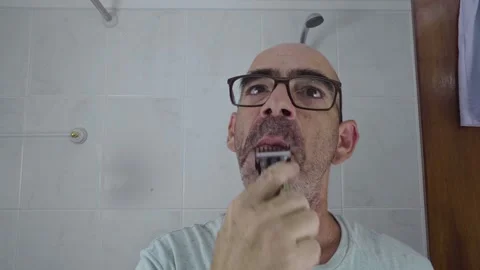 Man in bathroom shaving his beard Stock Footage 288092920