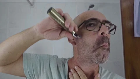 Man in bathroom shaving his beard Stock Footage 288092923