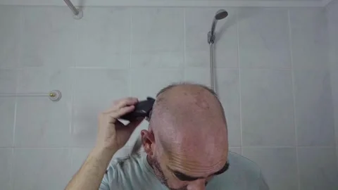 Man in bathroom shaving his head Stock Footage 287807641