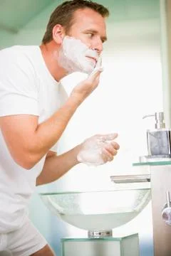 Man in bathroom shaving Stock Photos