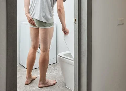 Man in bathroom suffering from chronic constipation and painful bowel movem.. Stock Photos