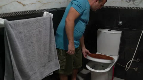 Man in the bathroom washes the toilet using a brush Stock Footage 101510358