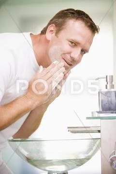 Man in bathroom washing face Stock-Fotos