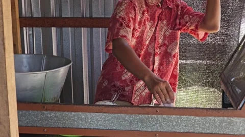 Man In Batik Shirt Preparing Local Street Food At A Food Stall Stock Footage 340046404