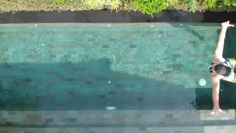 A man in beach clothes falls into the pool. Slow motion. Stock Footage 103423623